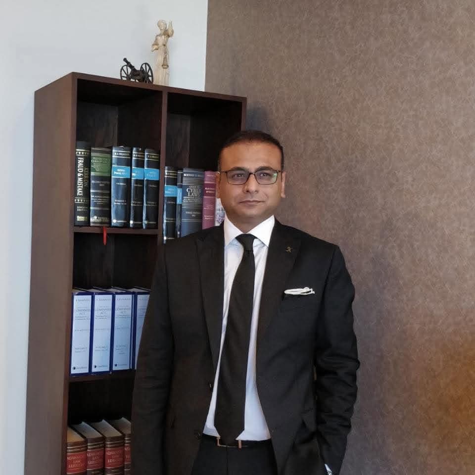 Khurram Chughtai in a law office beside a bookcase